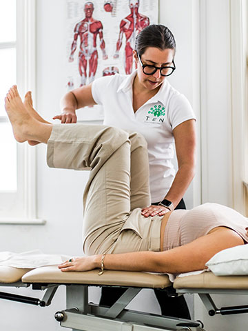 A physiotherapist treating a woman’s pelvic area in a women’s health physiotherapy appointment.